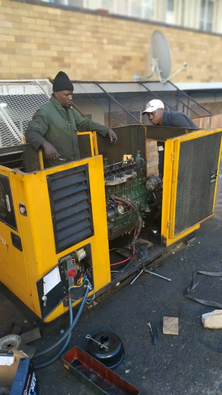 Technician performing maintenance on outdoor generator